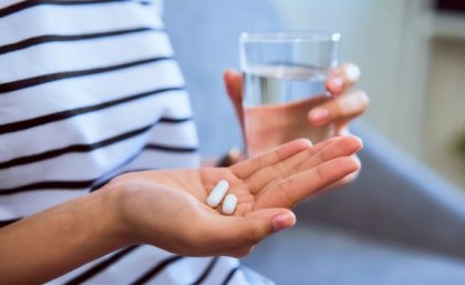 The trial shows it is possible to develop oral treatments for systemic diseases such as psoriasis. Image: Adobe close up of a person's hand holding two small white capsules in the background is their other hand holding a glass of water